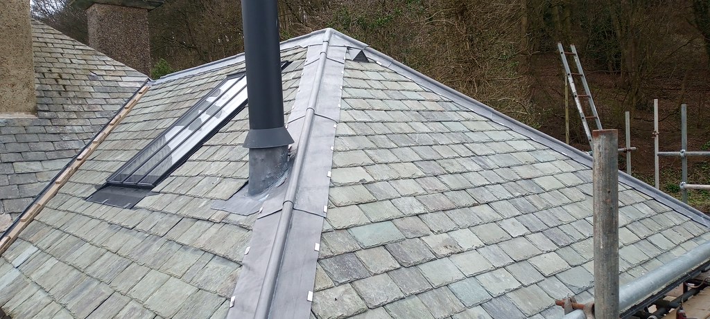 Completed slate roof with new lead ridges and skylight window by Greener Building